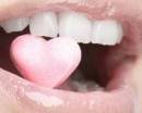 Бледно-розовый блеск на губах и сердечко во рту