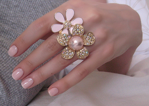 Розовый лак на ногтях и кольца "Цветы" на пальцах
