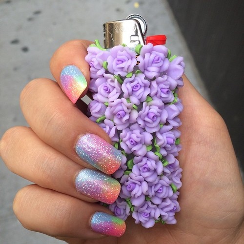 Флакон с  цветами в руке с блестящими ногтями