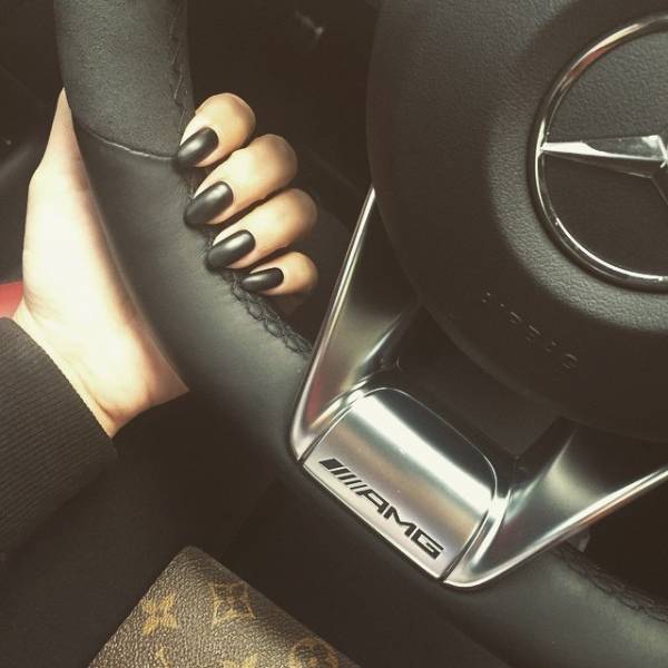 Чёрный матовый лак на ногтях девушки за рулём