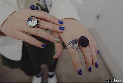Синий лак на ногтях рук с массивными кольцами