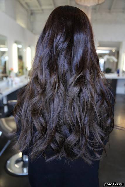 Длинные блестящие волнистые волосы брюнетки