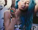 Девушка с длинными голубыми волосами курит сигарет