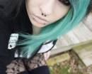 Эмо-девушка с черно-зелеными волосами с пирсингом