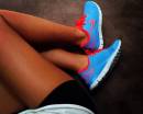 Девушка в голубых кроссовках Nike с красным лого