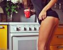 Девушка со спортивными ногами у плиты на кухне