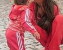 мама целует малышку дочку в спортивном костюме