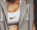 Девушка в белом топе Nike и серой безрукавке
