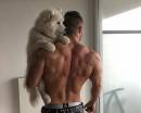 Спортивный парень с собакой на плече