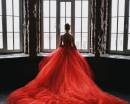 Девушка у окна в шикарном красном платье
