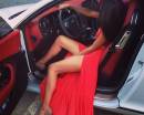 Брюнетка в красном платье за рулем авто