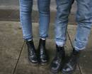Ноги парня и девушки в джинсах и черных ботинках