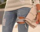 Девушка в рваных джинсах с бежевой сумочкой