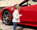 Мальчик у красной спортивной машины