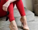 Девушка в красных джинсах стрейч и бежевых туфлях