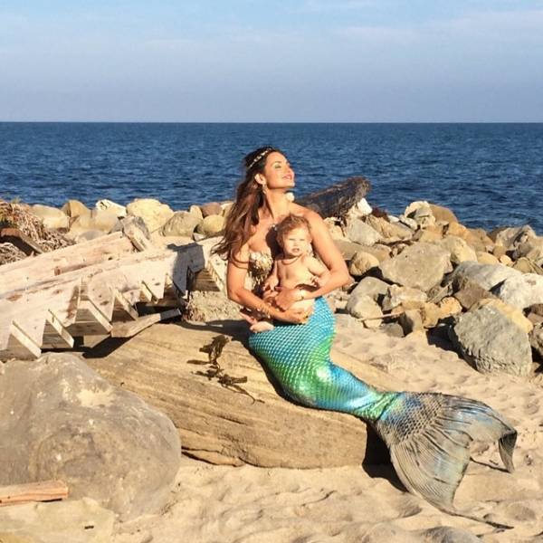 Русалка мама с малышом на камнях у моря