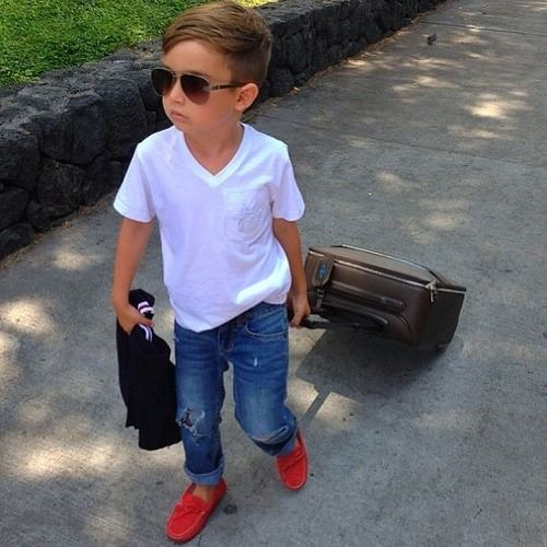 Стильный мальчик в джинсах, очках  с чемоданом