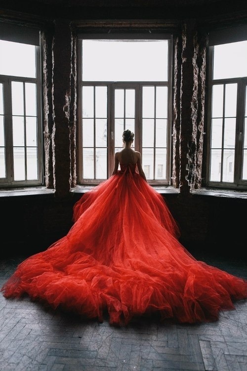 Девушка у окна в шикарном красном платье