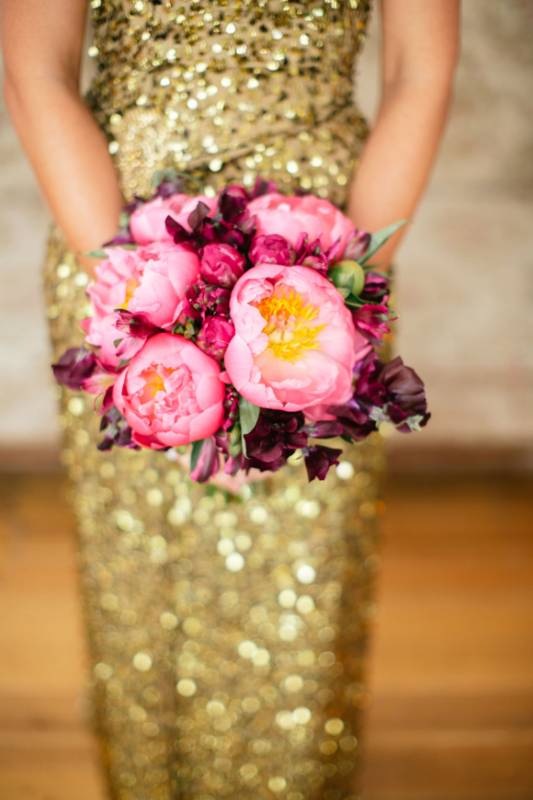 Букет розовых пионов в руках женщины в блестящем