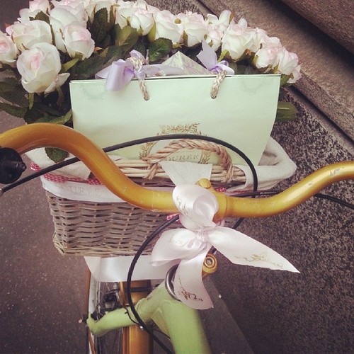 велосипед с букетом белых роз в корзине и подарки