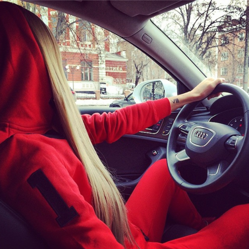 Блондинка в красном спортивном костюме за рулём