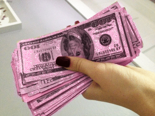 Блестящие розовые доллары в руке