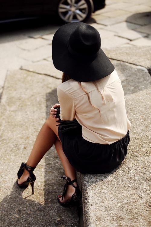 Женщина в черной шляпе, белой блузке и черной юбке