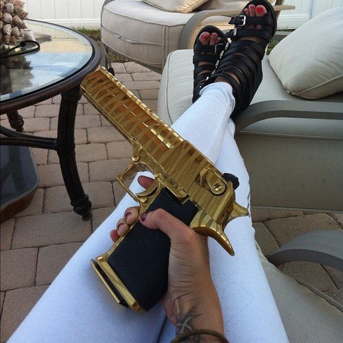 Девушка с золотисто-чёрным пистолетом в руке