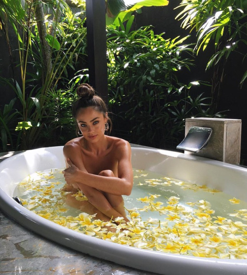 Девушка в ванне с лепестками желтых цветов
