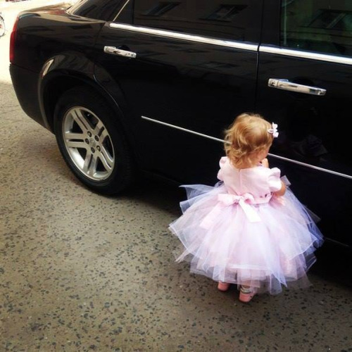 Девочка в белом пышном платье у черного авто