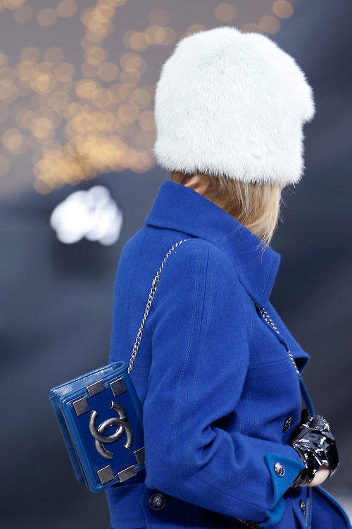В синем пальто, белой шапке и синей сумкой CHANEL