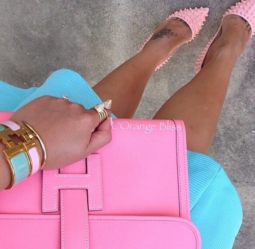 Розовые туфли с шипами и розовая сумка в руках