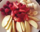 Порезанные на тарелке фрукты и ягоды