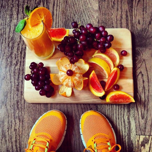 Ноги девушки в оранжевых кроссовках и фрукты