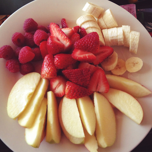 Порезанные на тарелке фрукты и ягоды