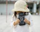 Девочка с фотоаппаратом в соломенной шляпке