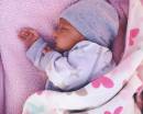 спящий на розовом покрывале младенец