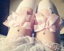 Ноги в белых чулках с розовыми подвязками и кружев