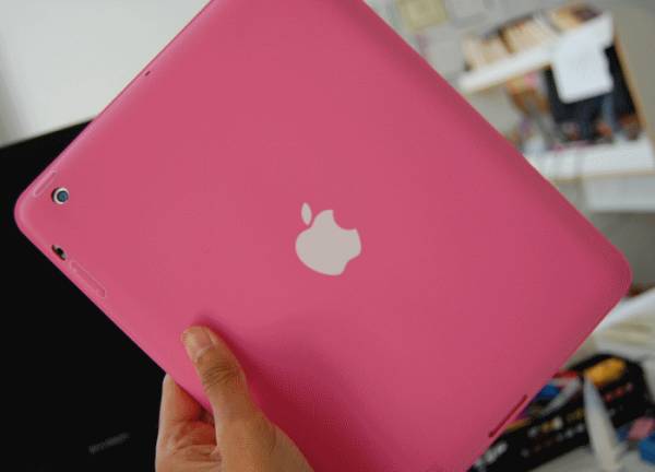 Розовый планшетный компьютер Apple iPad в руке