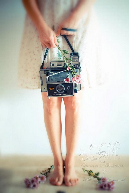Девушка в платье с фотоаппаратом в руке