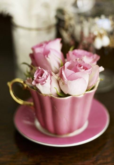 Розовые розы в фарфоровой чашечке с блюдцем