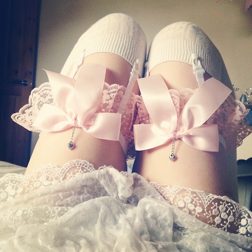Ноги в белых чулках с розовыми подвязками и кружев