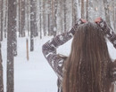 Девушка в свитере в заснеженном лесу (со спины)