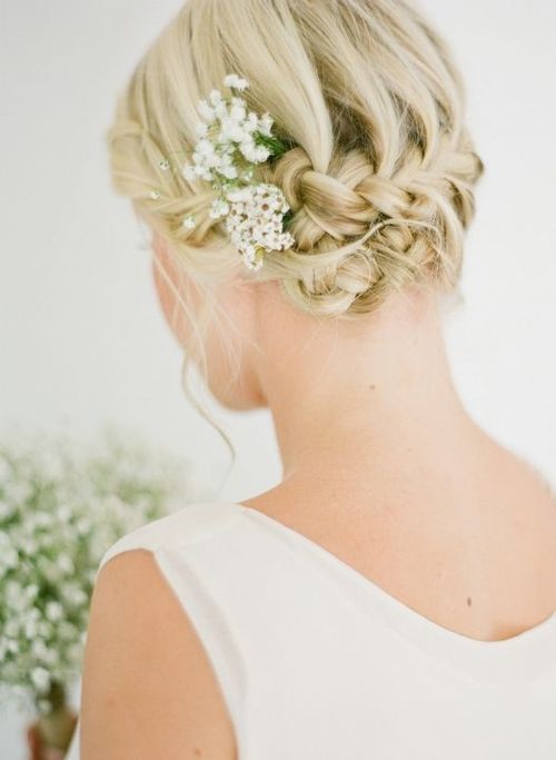 Прическа блондинки с плетением с цветами в волосах
