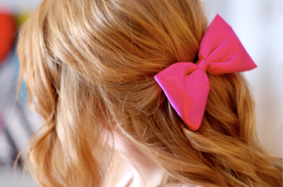 Розовый бантик на волосах блондинки