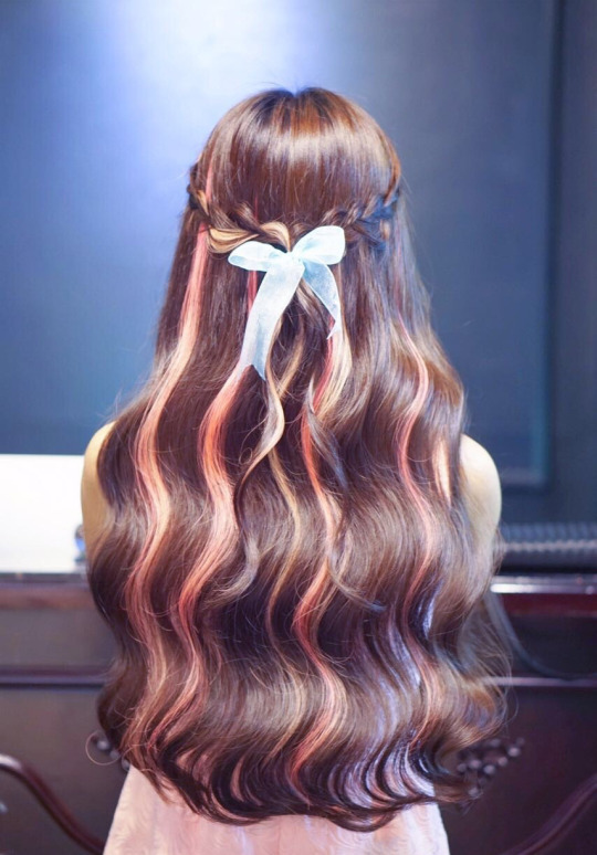 Розовые прядки на волнистых каштановых волосах